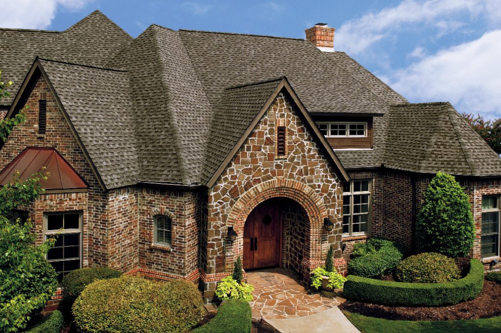 A large brick house with a stone front and a brick walkway.