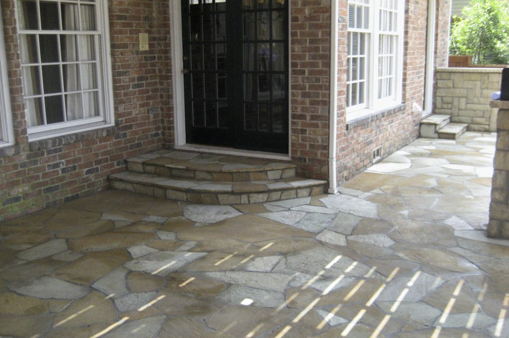 A porch with steps leading to the front door.