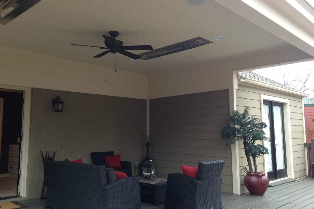 A patio with couches and chairs, table and ceiling fan.