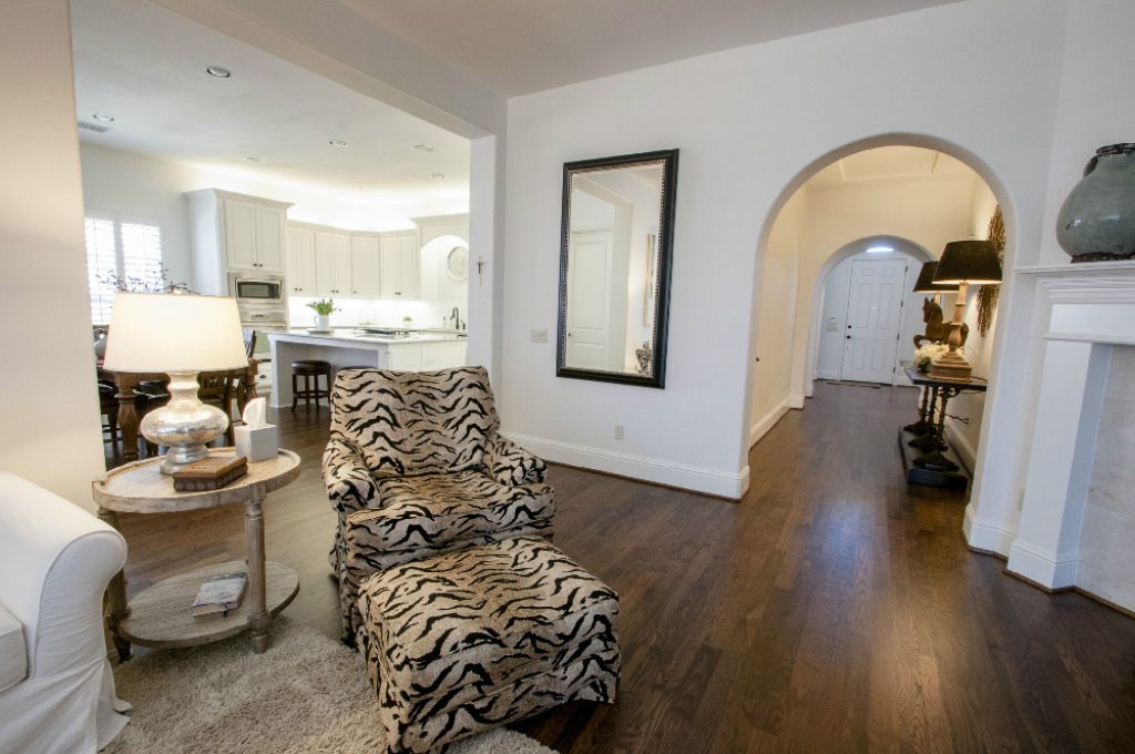 A living room with a zebra print chair and wooden floors