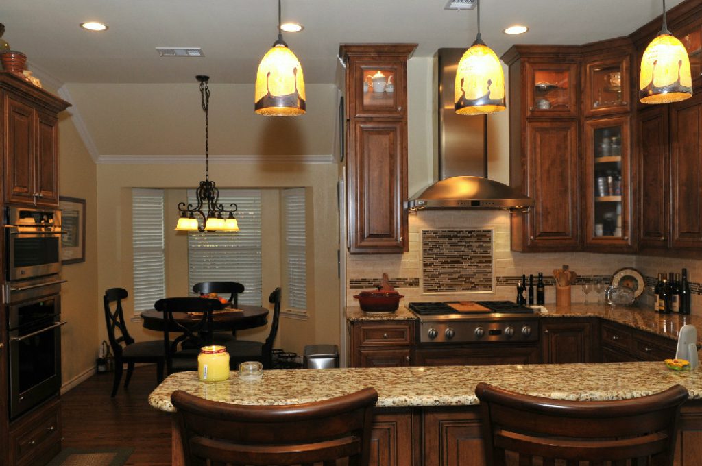 A kitchen with wooden cabinets and granite counter tops.