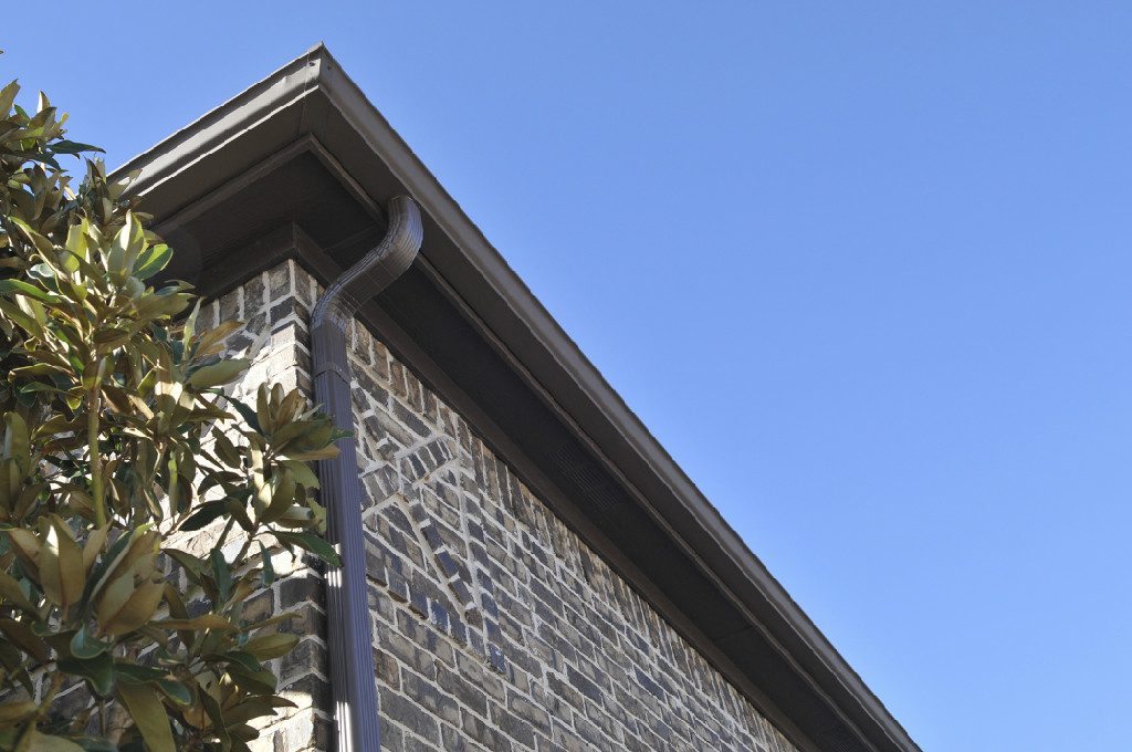 A close up of the corner of a building with a gutter