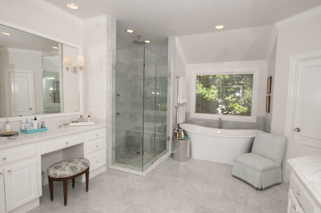 A bathroom with a tub, sink and shower.