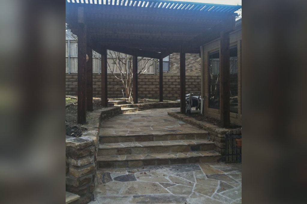 A patio with steps leading to the back yard.