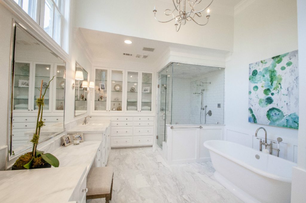 A large white bathroom with a glass shower door.