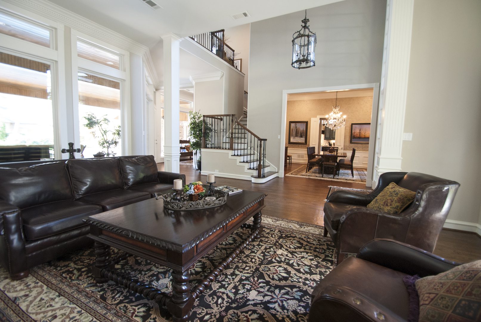 55cb9c48a5439fdb55c5f3a66b586243 A living room with couches, tables and stairs.