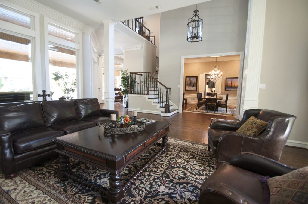 A living room with leather furniture and a large rug.