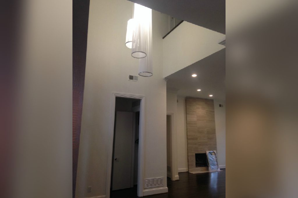 A hallway with a fireplace and two lights.