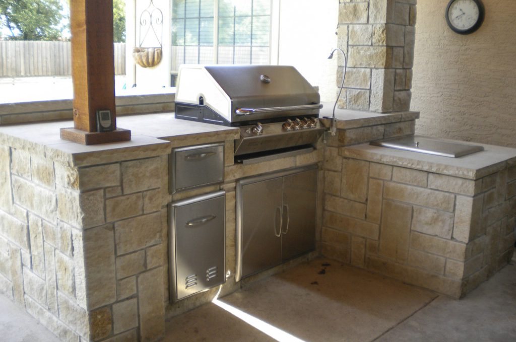 A grill in the middle of an outdoor kitchen.