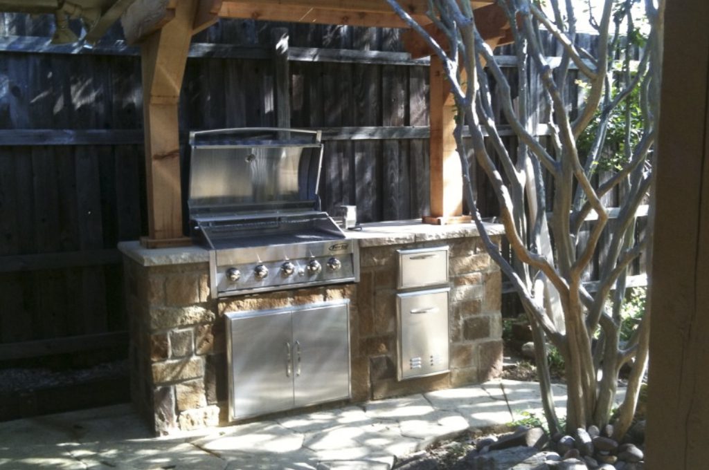 A grill and oven in an outdoor kitchen.