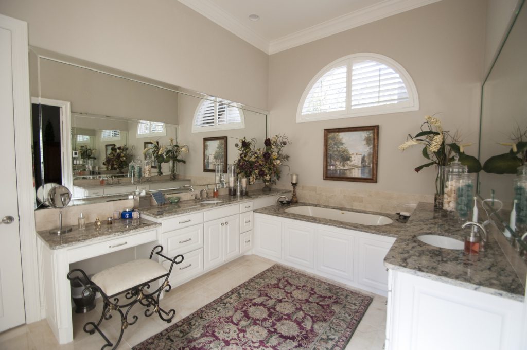 A bathroom with a sink, tub and mirror.