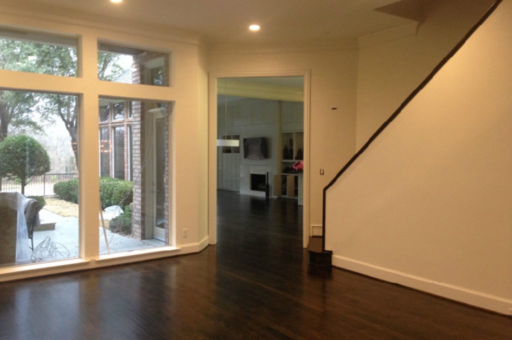 A room with dark wood floors and white walls.
