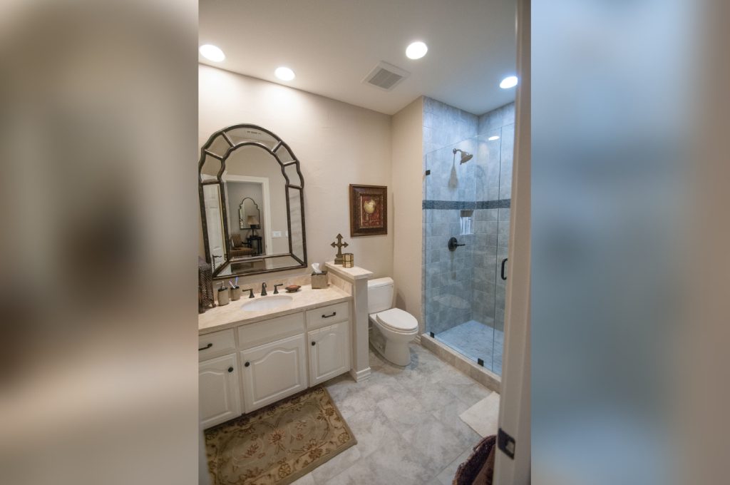 A bathroom with a toilet, sink and shower.