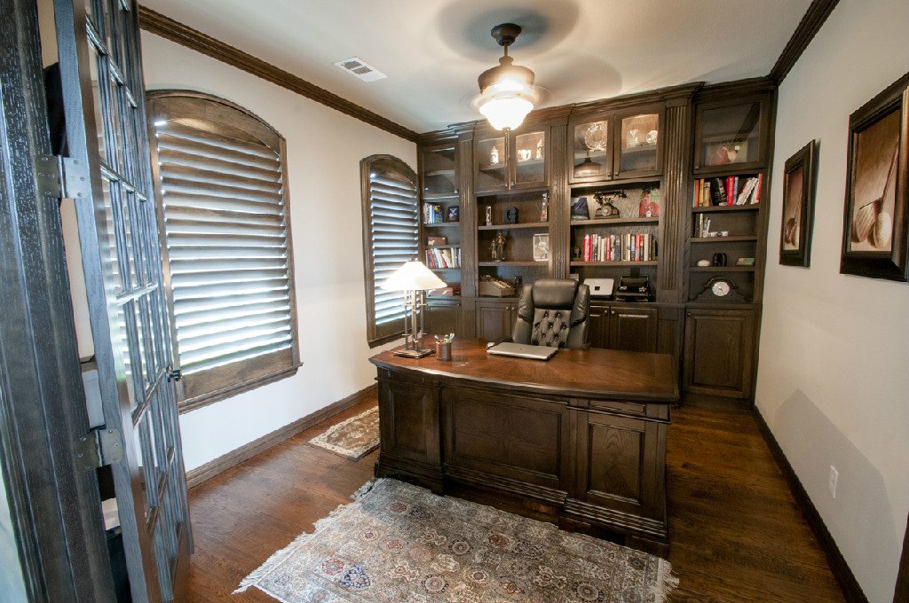 A home office with a desk and bookcase.