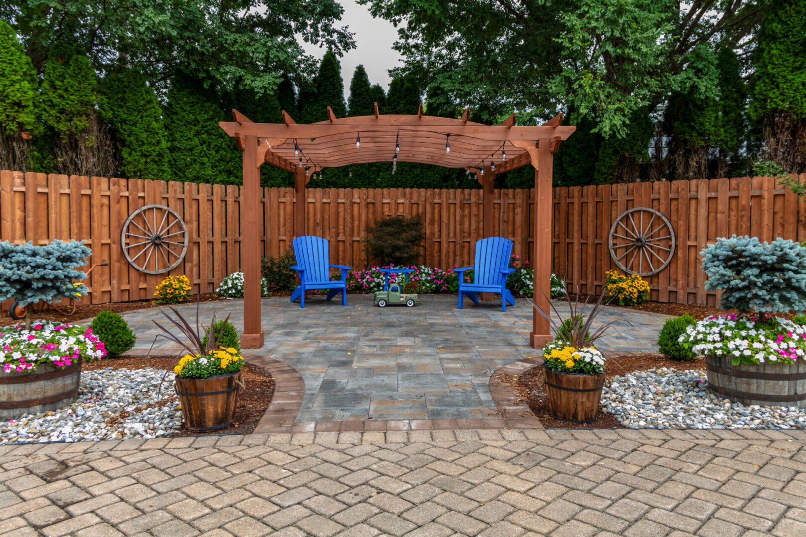 Garden patio with chairs and wooden pergola.