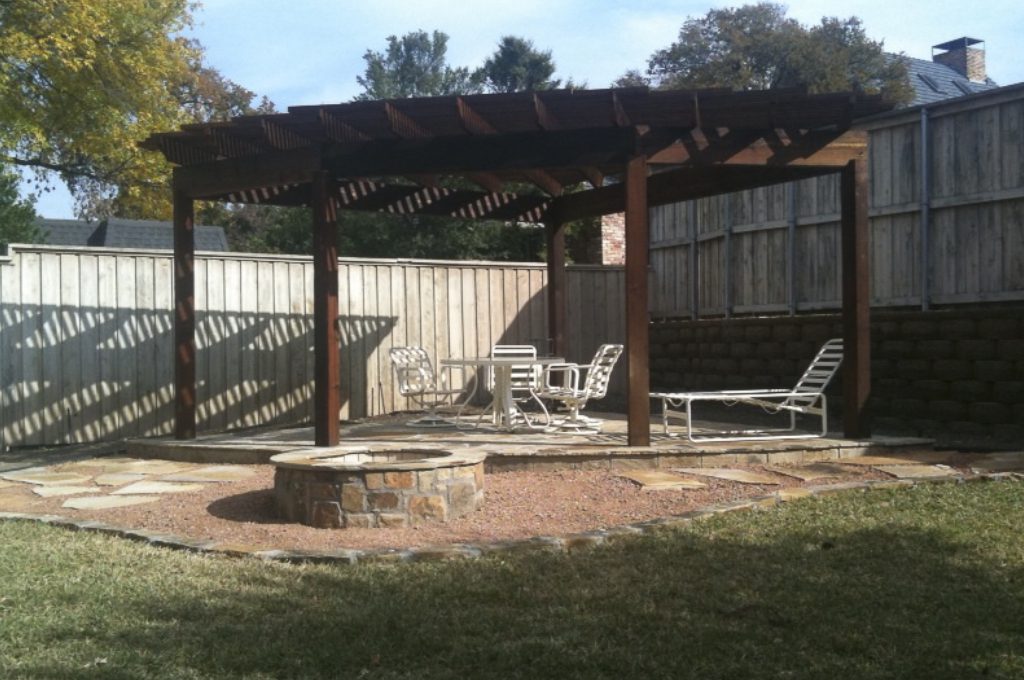A fire pit and chairs in the back yard.