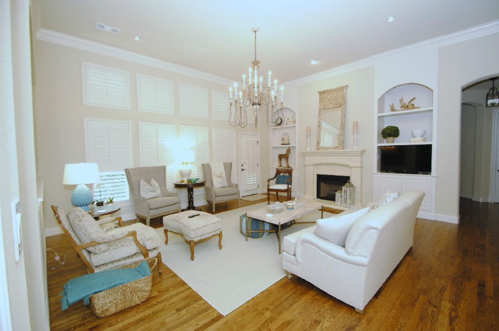 A living room with white furniture and wooden floors