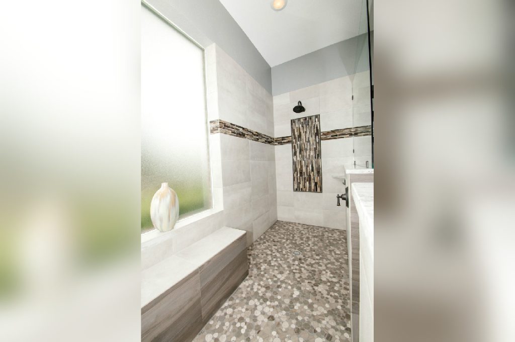 A bathroom with a tub, sink and mirror.