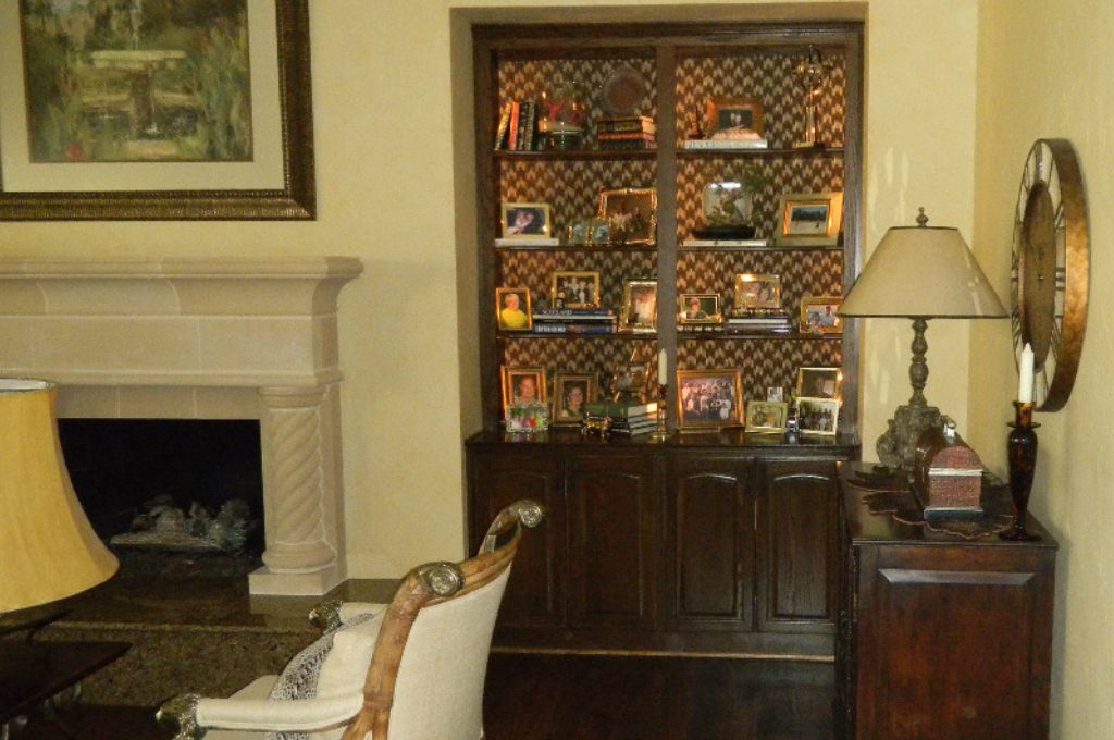A living room with a fireplace and a china cabinet.