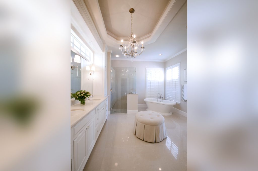 A bathroom with white cabinets and a tub
