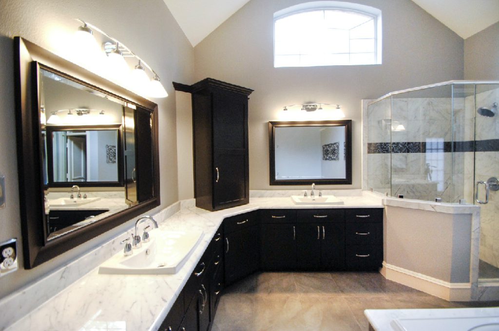 A bathroom with two sinks and a large mirror.