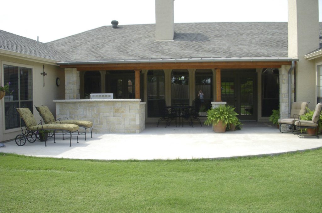 A patio with an outdoor grill and lawn furniture.
