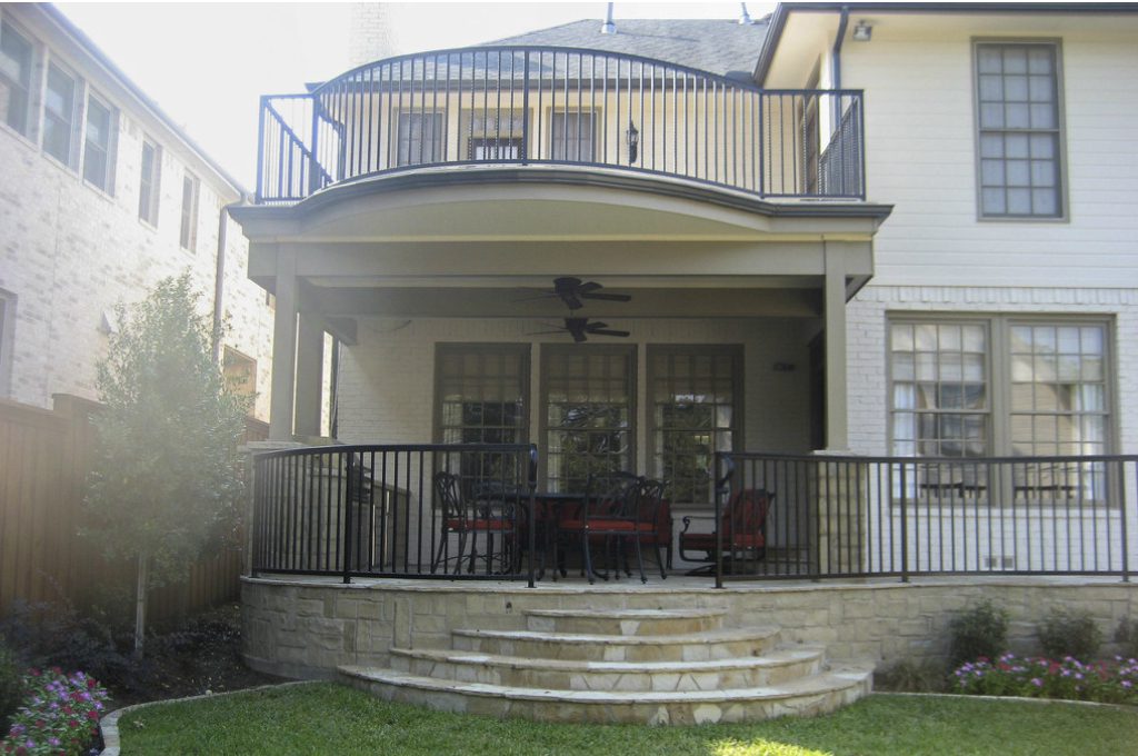 A large patio with stairs leading to the back of the house.