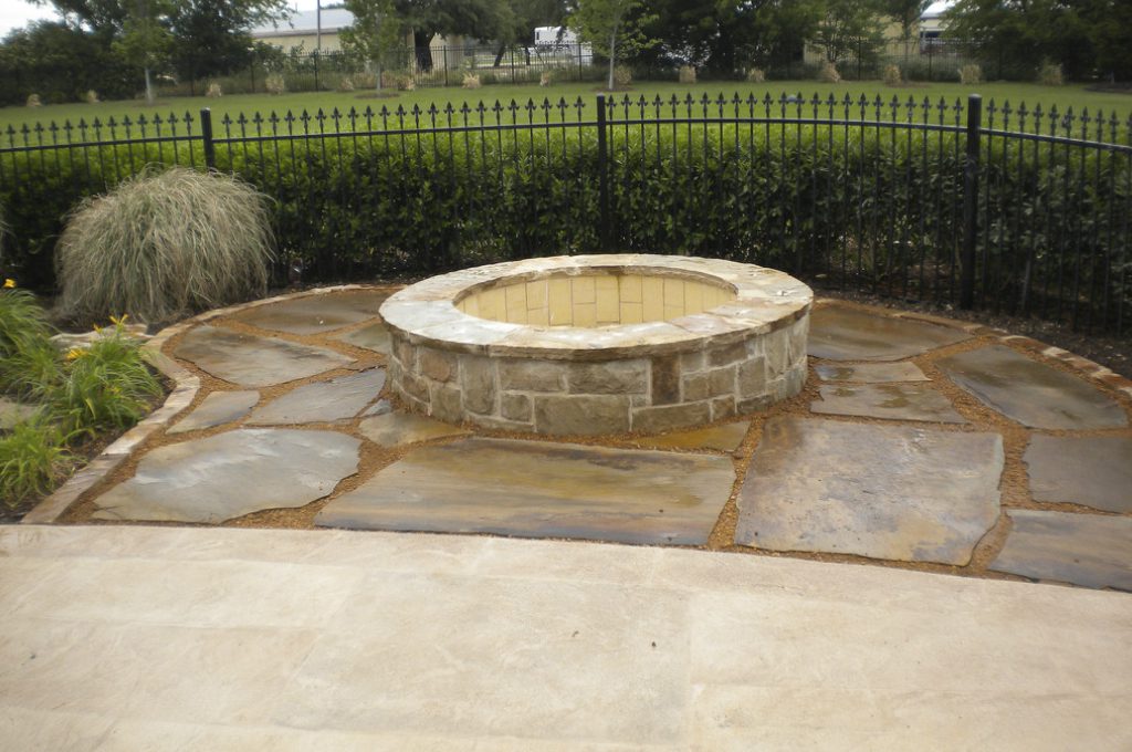 A fire pit sitting on top of a stone patio.