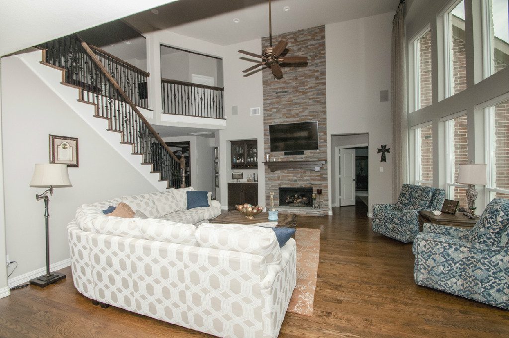 A living room with a couch, chair and fireplace.